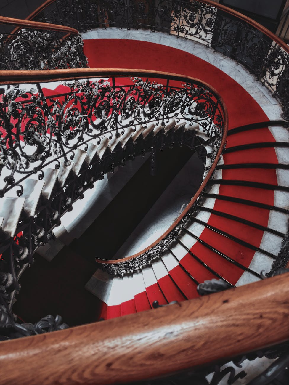 high angle photo of staircase with red carpet